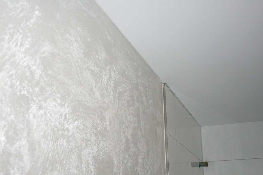 Badezimmergestaltung mit einer Spanndecke. Wände mit einer metallischen Lasur und Kristallzugabe veredelt