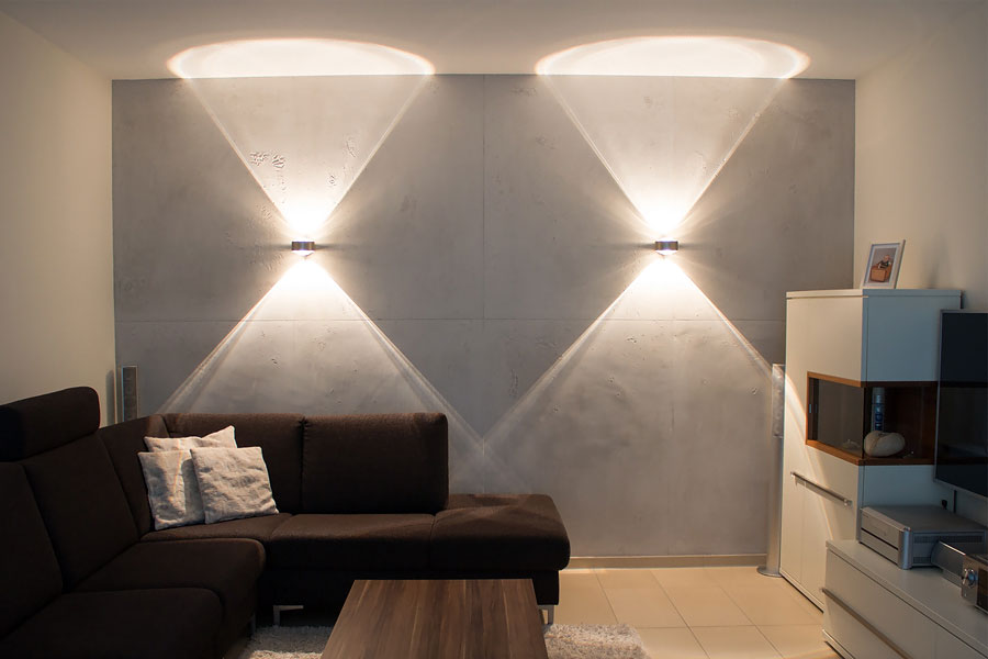 Akzentbeleuchtung auf einer Betonoptik-Wand erzeugt dramatische Lichtkegel.