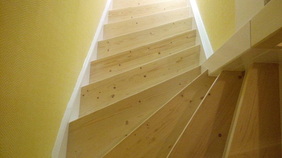 Deckend lackierte Holztreppe abgeschliffen, Trittstufen farblos lackiert sowie Setzstufen und Wangen weiß lackiert