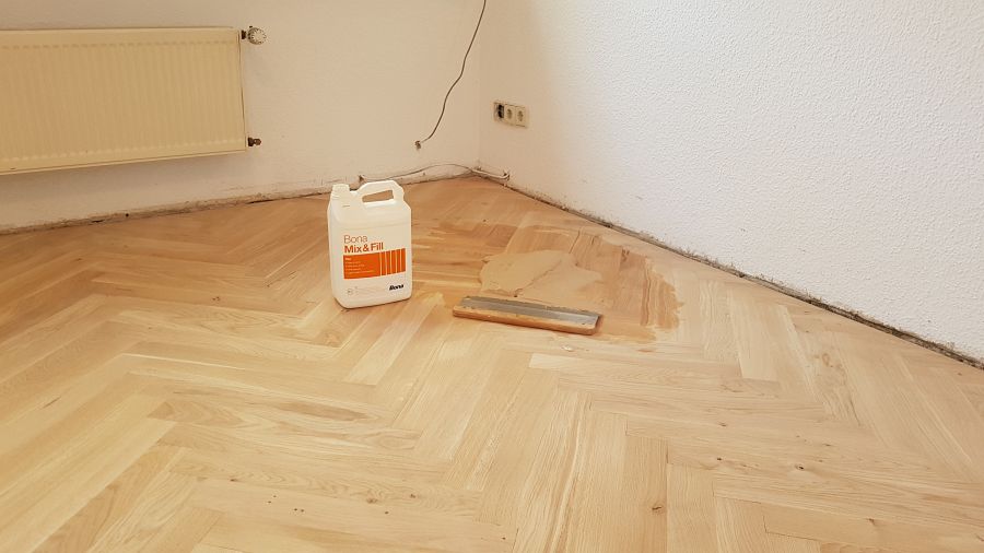 Eiche massiv Parkett, 22mm stark, im Fischgrat Verband verlegt und endbehandelt. Inkl. Fußleistenmontage.