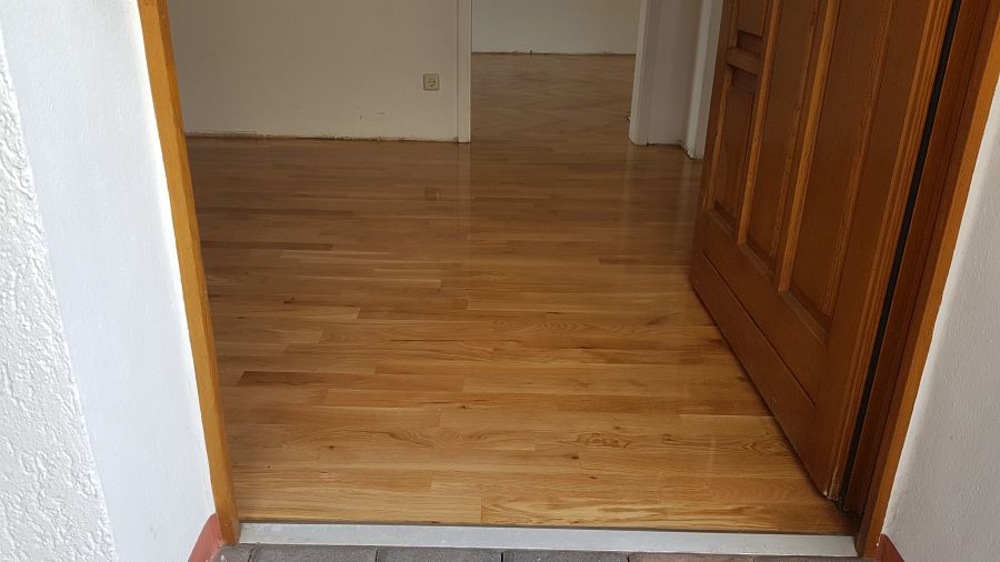 Eiche massiv Parkett, 22mm stark, im Fischgrat Verband verlegt und endbehandelt. Inkl. Fußleistenmontage.