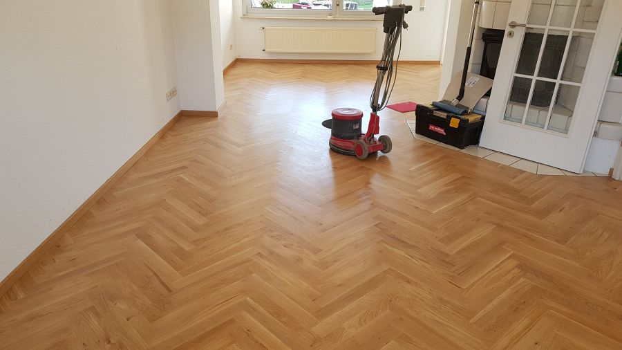 Eiche massiv Parkett, 22mm stark, im Fischgrat Verband verlegt und endbehandelt. Inkl. Fußleistenmontage.