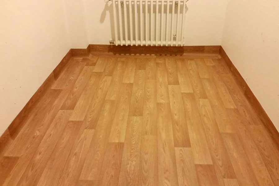 Heterogener PVC–Belag in Holzoptik verlegt. Sockel wannenförmig ausgebildet und Fugen thermisch verschweißt.