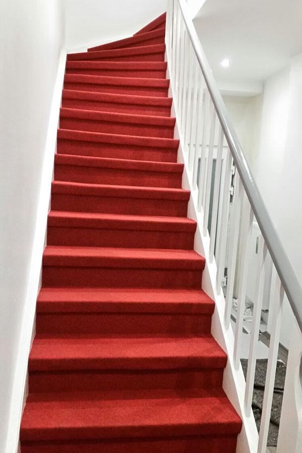 Historische Holztreppe mit königlich roten Textilbelag veredelt