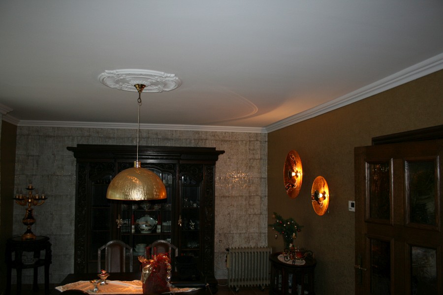 Wohn-, Eßzimmer mit Stuck an der Decke und einer Wandverkleidung aus handverarbeitetem Kork auf Goldlamee und mit goldfarbig bedrucktem Vlies aufgewertet